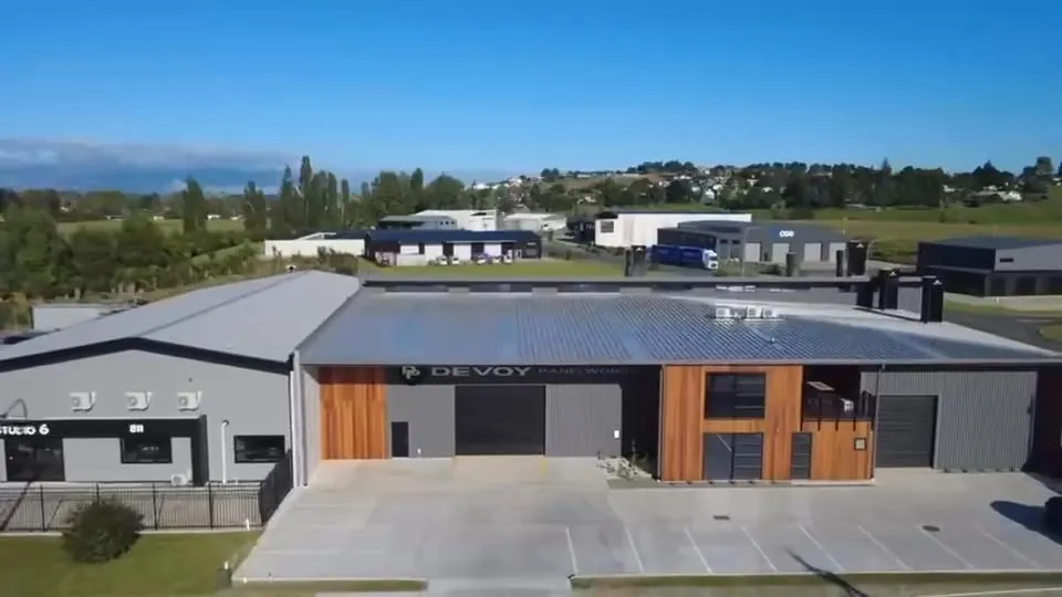Devoy Panelworks workshop at 3 Riverhurst Drive, Te Awamutu, charcoal and cedar cladding, drone shot, February 2026.